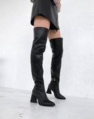Schwarze Overknee-Stiefel aus Leder mit Blockabsatz, modisch und elegant, ideal für Herbst- und Winteroutfits. Perfekt für trendbewusste Frauen.