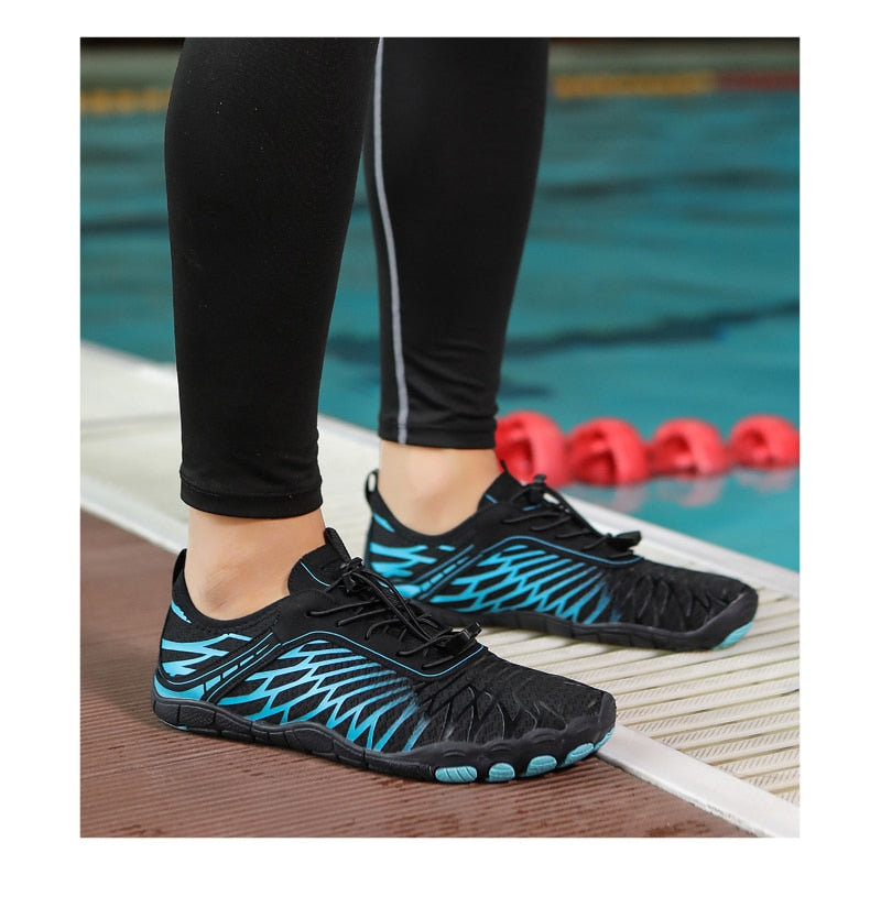 Schwarze und blaue Wasserschuhe am Poolrand, ideal für Schwimmen und Wassersport. Rutschfest, atmungsaktiv, schnell trocknend.
