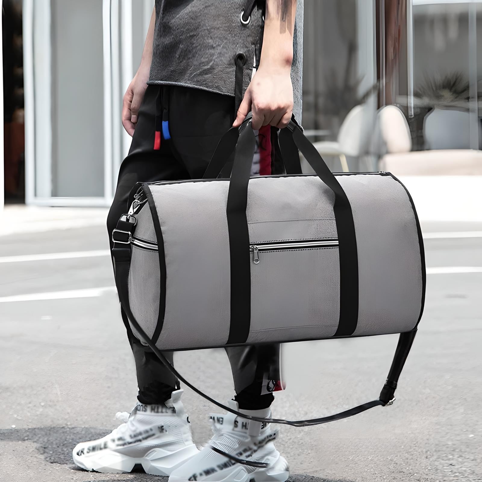 Graue Sporttasche mit schwarzen Trägern, Reißverschluss, ideal für Fitness und Reisen.