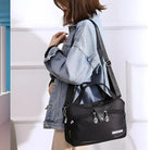 Frau mit schwarzer Umhängetasche, lässige Mode, Denim-Jacke, stilvolles Accessoire.