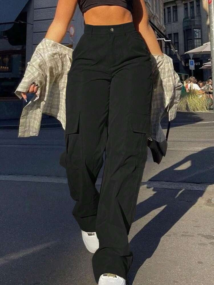 Trendige Damenmode: Schwarze Cargohose kombiniert mit Crop-Top und kariertem Hemd. Perfekt für urbanen Streetstyle und lässige Outfits.