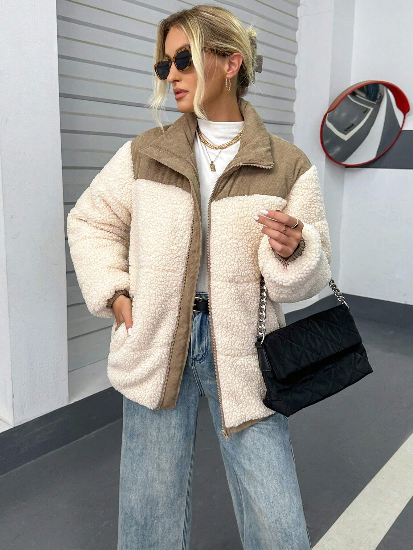 Damenmode: Stylische Teddyjacke in Beige, kombiniert mit schwarzer Umhängetasche und blauer Jeans. Perfekt für trendige Herbst-Looks.