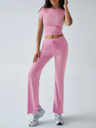 Damen-Sportoutfit in Rosa: Figurbetontes Crop-Top und weite Jogginghose, ideal für Fitness und Freizeit. Trendige Sportmode für Frauen.