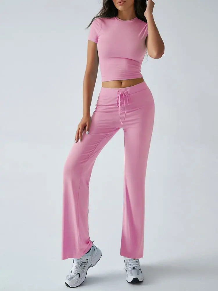 Damen-Sportoutfit in Rosa: Figurbetontes Crop-Top und weite Jogginghose, ideal für Fitness und Freizeit. Trendige Sportmode für Frauen.