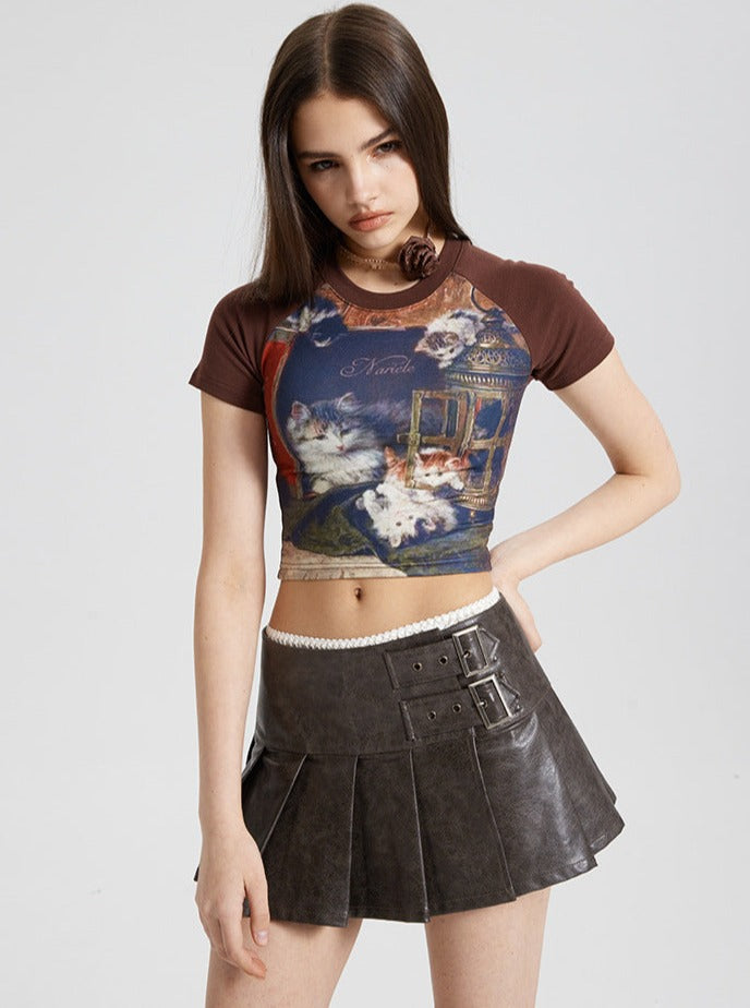 Frau in modischem Crop-Top mit Katzenmotiv und braunem Faltenrock. Trendige Damenmode, stilvolle Kleidung, urbaner Look.