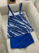 Blaues Batik-Tankini-Set auf Sofa, Damen-Bademode, modisches Design, Sommerkleidung, Strandoutfit, bequem und stilvoll.