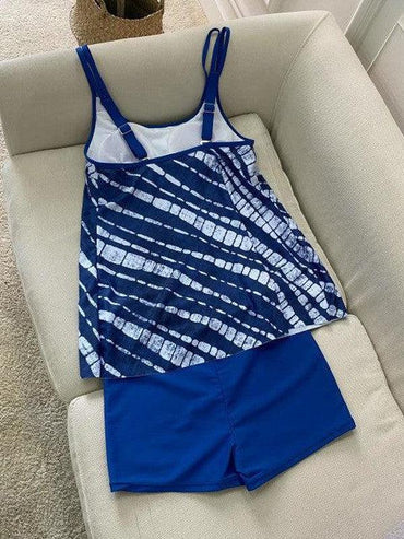 Blaues Batik-Tankini-Set auf Sofa, Damen-Bademode, modisches Design, Sommerkleidung, Strandoutfit, bequem und stilvoll.