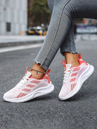 Damen Sneaker rosa-weiß, atmungsaktiv, sportlich, Straßenhintergrund, modische Freizeitschuhe.