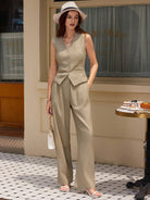Eleganter Damenanzug in Beige, ärmelloses Design, kombiniert mit Hut und Sandalen. Perfekt für stilvolle Sommermode und urbane Eleganz.