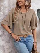 Frau in beigem Rüschen-Top und blauer Jeans, lässiger Look, Mode, Damenbekleidung.