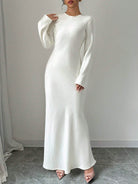 Elegantes weißes Abendkleid mit langen Ärmeln, figurbetontem Schnitt und fließendem Stoff. Perfekt für formelle Anlässe und Hochzeiten.