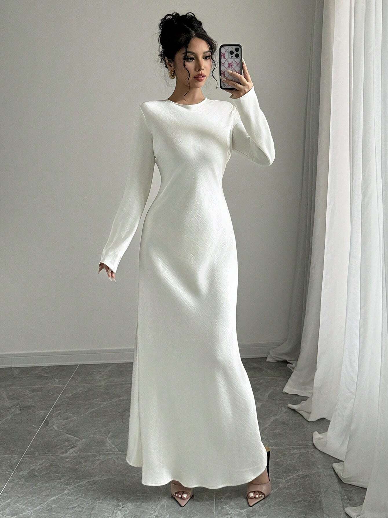 Elegantes weißes Maxikleid mit langen Ärmeln, ideal für Hochzeiten oder formelle Anlässe. Zeitloses Design, perfekte Passform, stilvoll und modern.