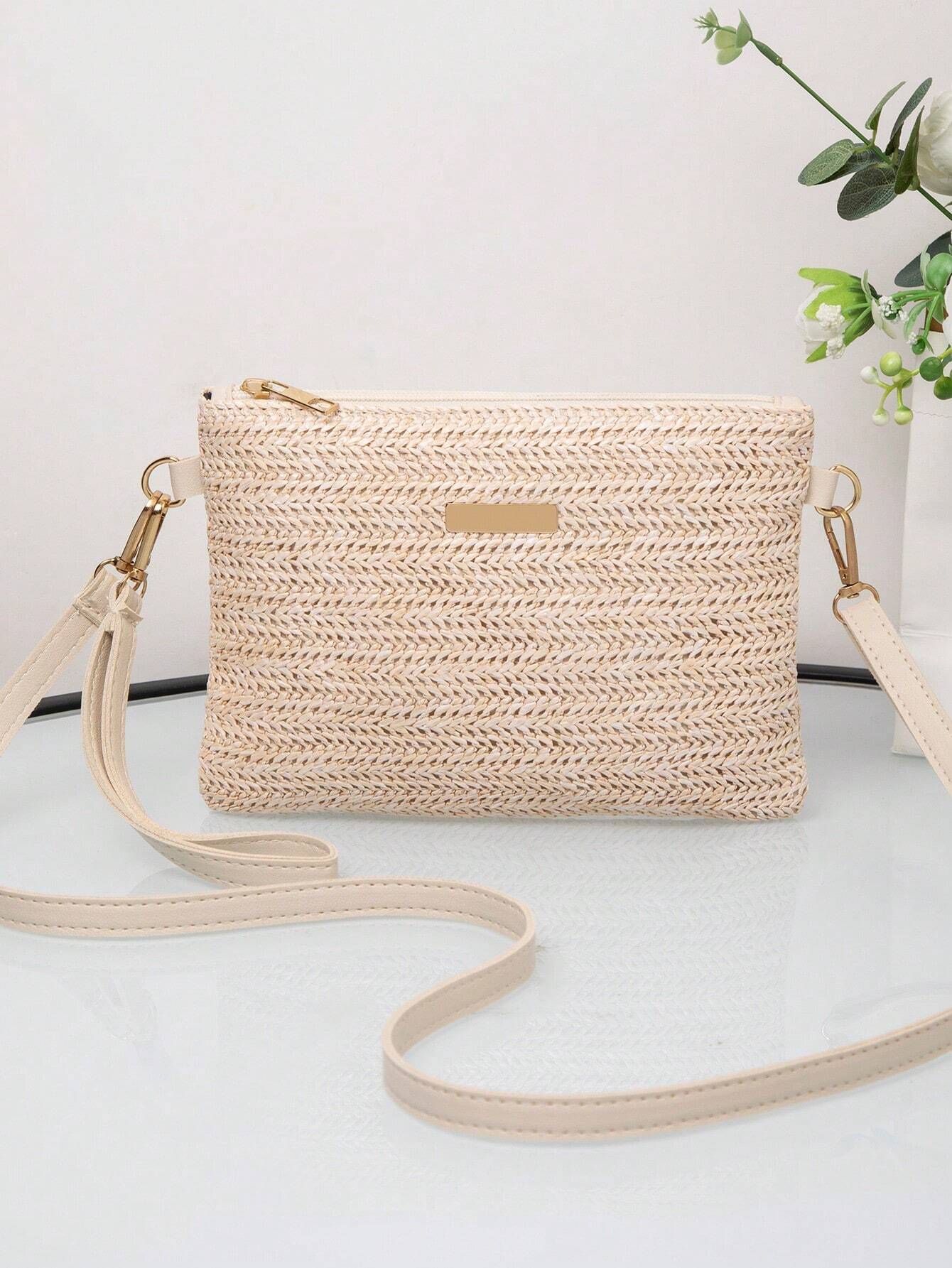 Beige Umhängetasche aus Stroh mit goldenen Details, ideal für Sommermode und Freizeit.