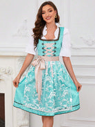 Frau im türkisfarbenen Dirndl mit weißer Bluse und Spitzenapplikationen, traditionelles bayerisches Kleid, ideal für Oktoberfest und Trachtenmode.