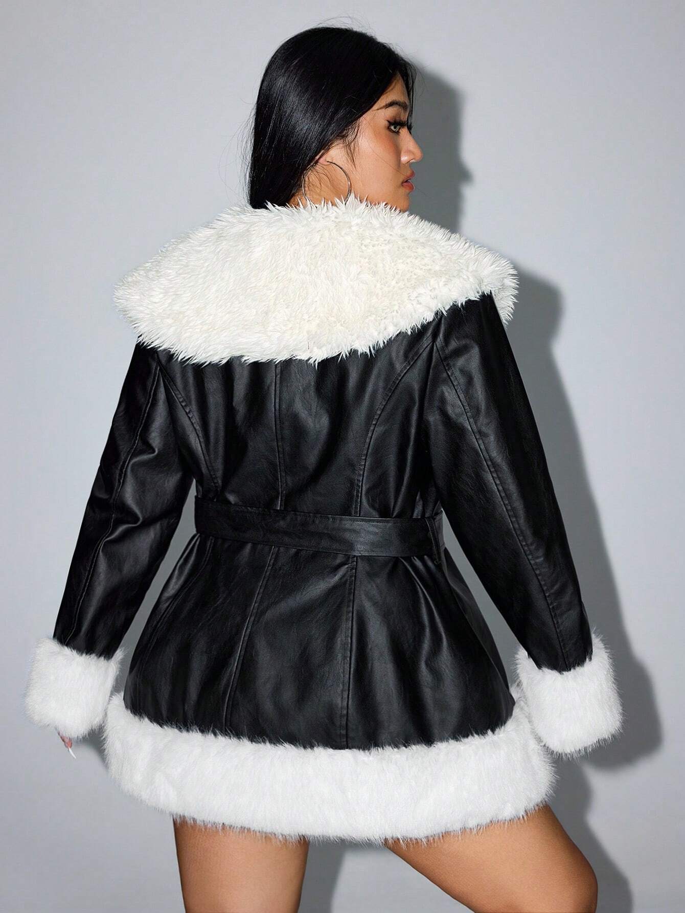 Schwarzer Kunstledermantel mit weißem Kunstfellkragen und -manschetten, modisch, elegant, Damenmode, Winterjacke, stilvoller Look.