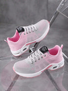 Graue und rosa Damen-Sneaker auf transparentem Stuhl, atmungsaktiv, sportlich, modisch.