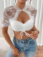 Damen-Spitzenoberteil in Weiß, kurzärmelig, mit Schnürung und floralem Muster. Perfekt für modische Outfits und elegante Anlässe.
