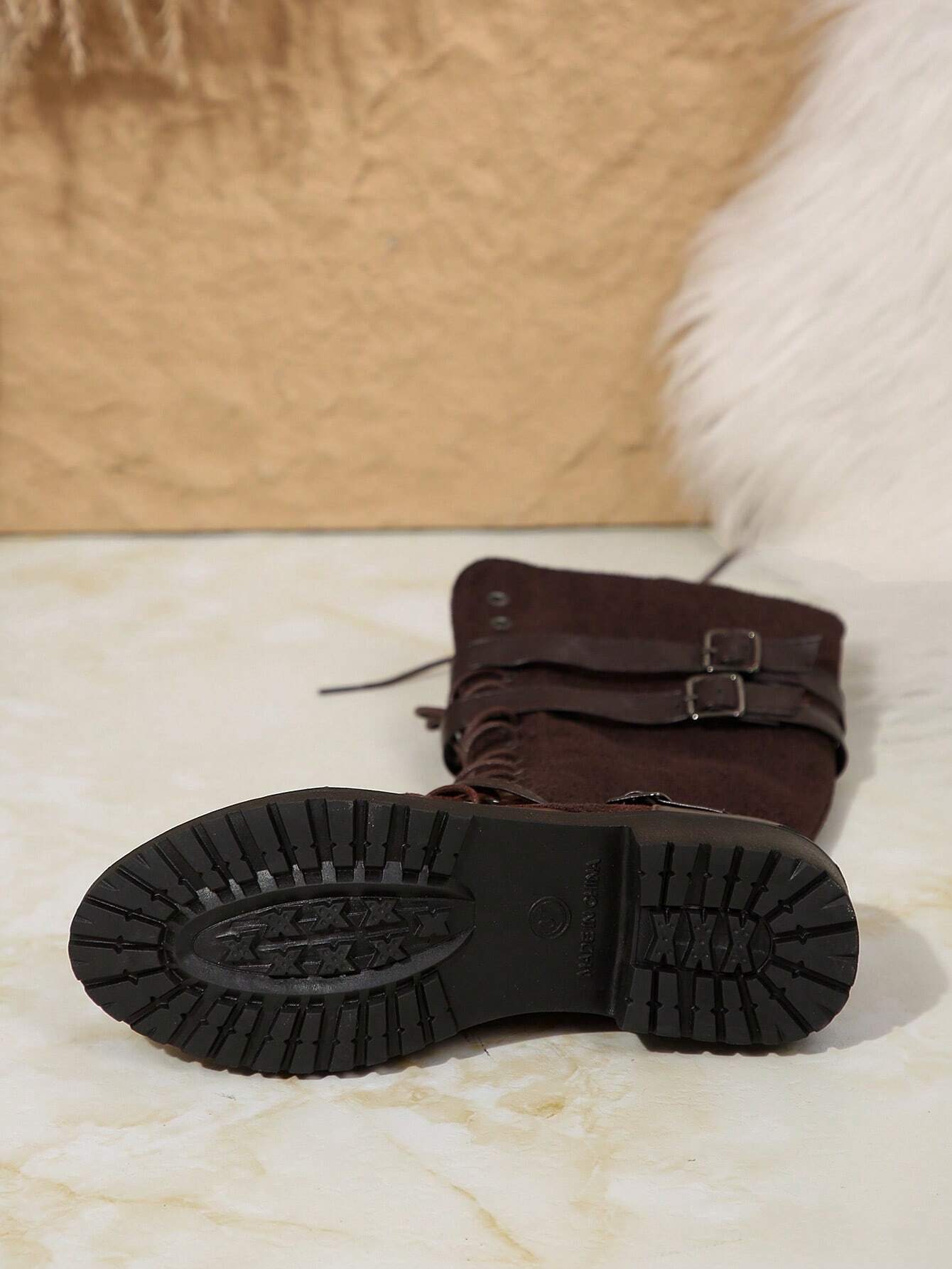 Damenstiefel mit robuster Gummisohle, braunem Wildleder, Schnallen und Schnürung. Perfekt für Herbstmode und Outdoor-Aktivitäten.