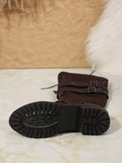 Damenstiefel mit robuster Gummisohle, braunem Wildleder, Schnallen und Schnürung. Perfekt für Herbstmode und Outdoor-Aktivitäten.