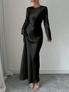 Elegantes schwarzes Maxikleid mit langen Ärmeln, figurbetontem Schnitt und fließendem Stoff. Perfekt für Abendveranstaltungen und formelle Anlässe.