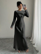 Elegantes langärmeliges schwarzes Maxikleid, ideal für Abendveranstaltungen. Perfekt kombiniert mit offenen Sandalen. Zeitloser, stilvoller Look.