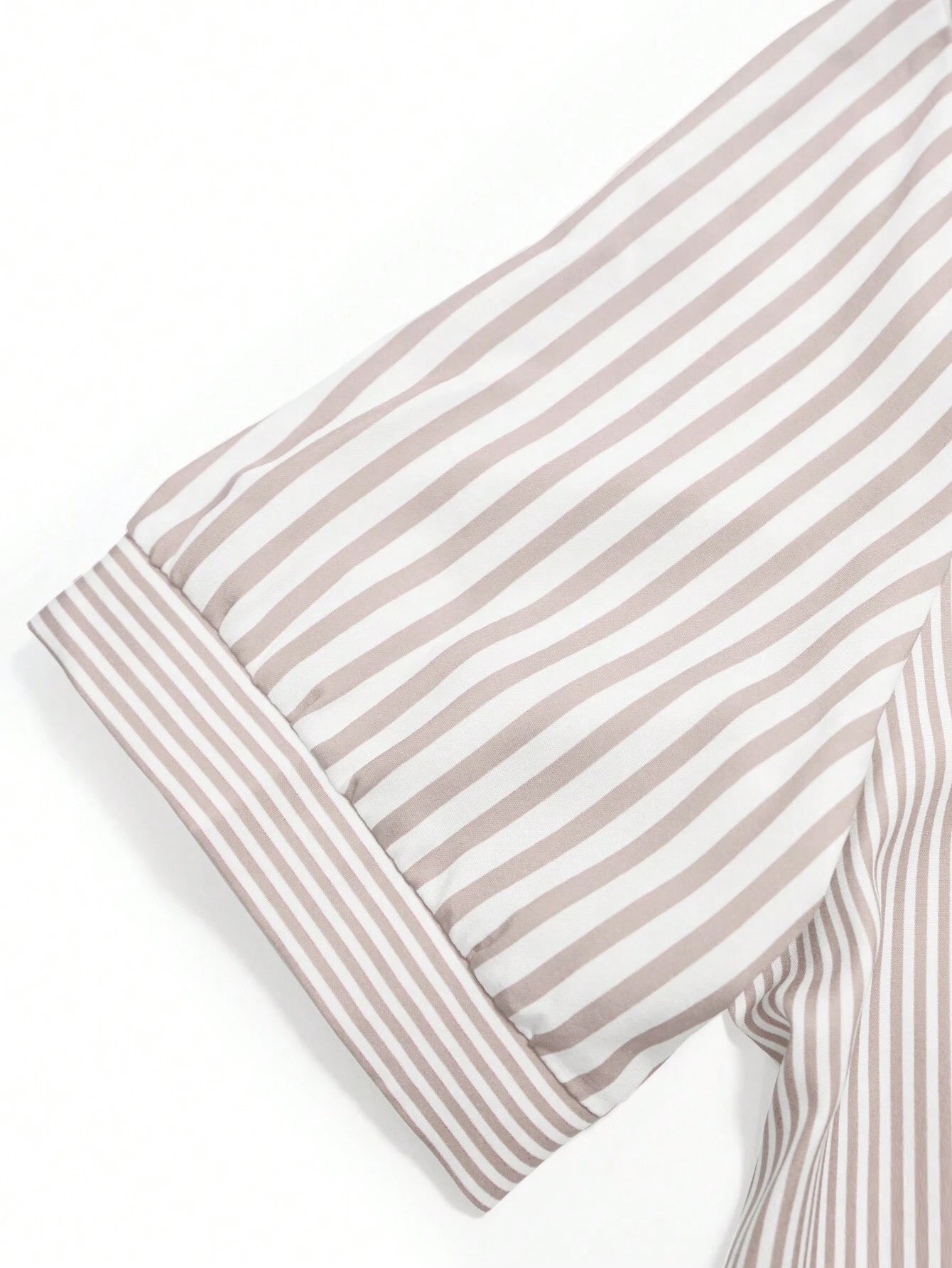 Gestreiftes Hemdärmel-Detail in Beige und Weiß, hochwertiger Baumwollstoff, modisches Design, ideal für Business- und Freizeitkleidung.