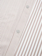 Gestreiftes Hemd in Beige und Weiß, Nahaufnahme. Hochwertige Baumwolle, klassisches Design, ideal für Business und Freizeitmode.