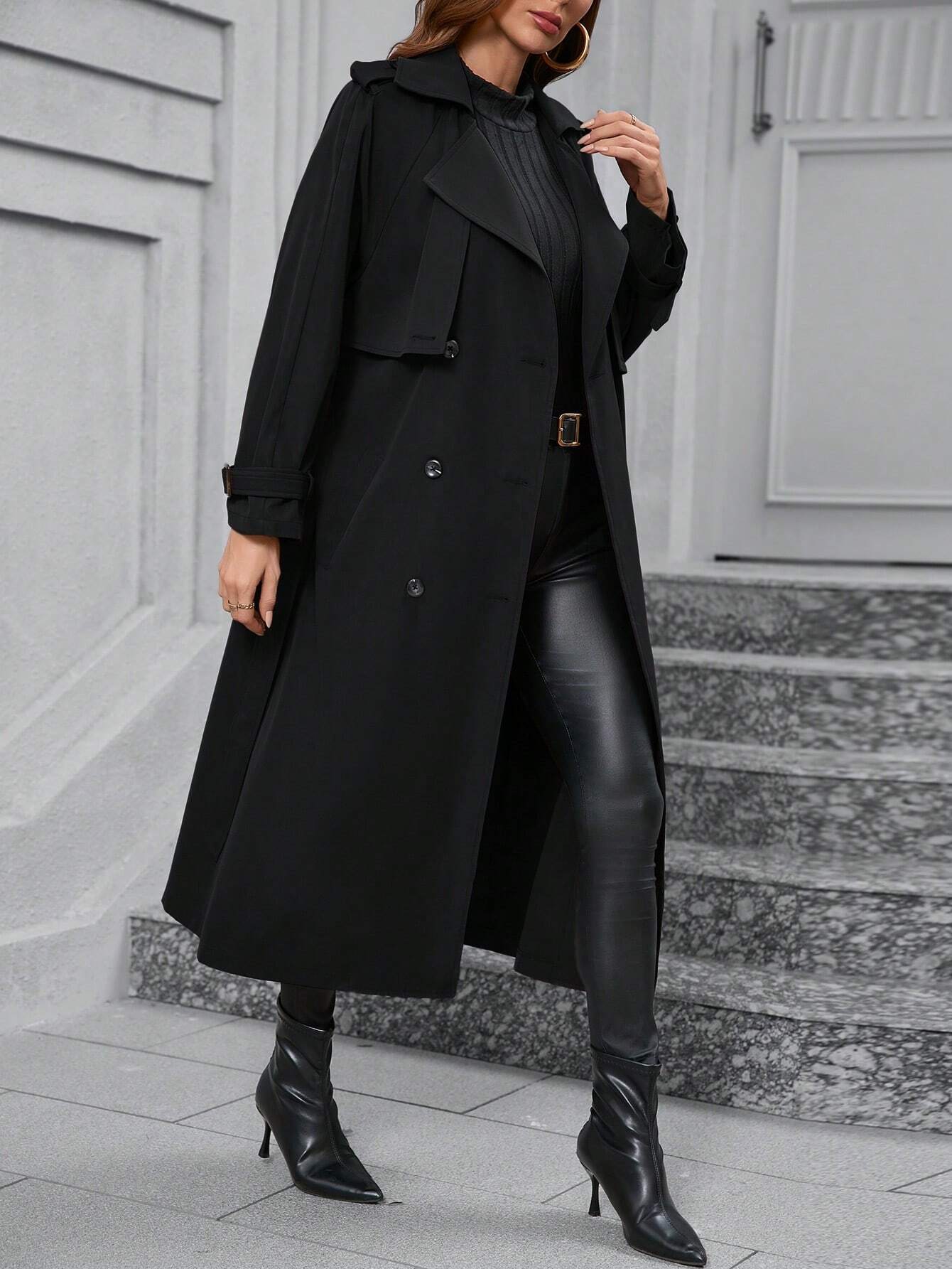 Eleganter schwarzer Trenchcoat für Damen, ideal für Herbstmode. Kombiniert mit Lederleggings und Stiefeletten für einen stilvollen Look.