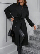 Eleganter schwarzer Trenchcoat für Damen, kombiniert mit Lederleggings und gesteppter Handtasche. Perfekt für stilvolle Herbstmode.