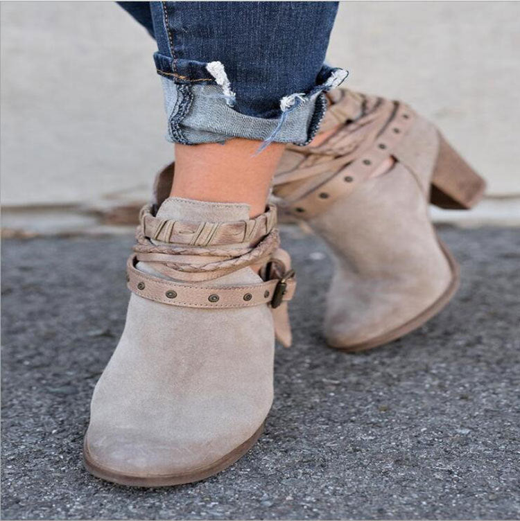 Damenstiefeletten aus Wildleder in Beige mit dekorativen Riemen und Nieten, kombiniert mit hochgekrempelten Jeans. Trendige Herbstmode.