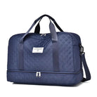 Dunkelblaue Reisetasche mit Tragegriffen und Schultergurt, gestepptes Design, geräumig.