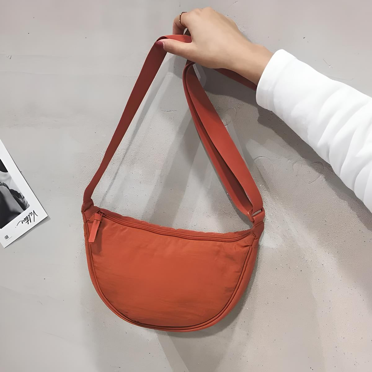 Orange Umhängetasche aus Stoff, halbmondförmig, modisch, handgehalten, minimalistisch.