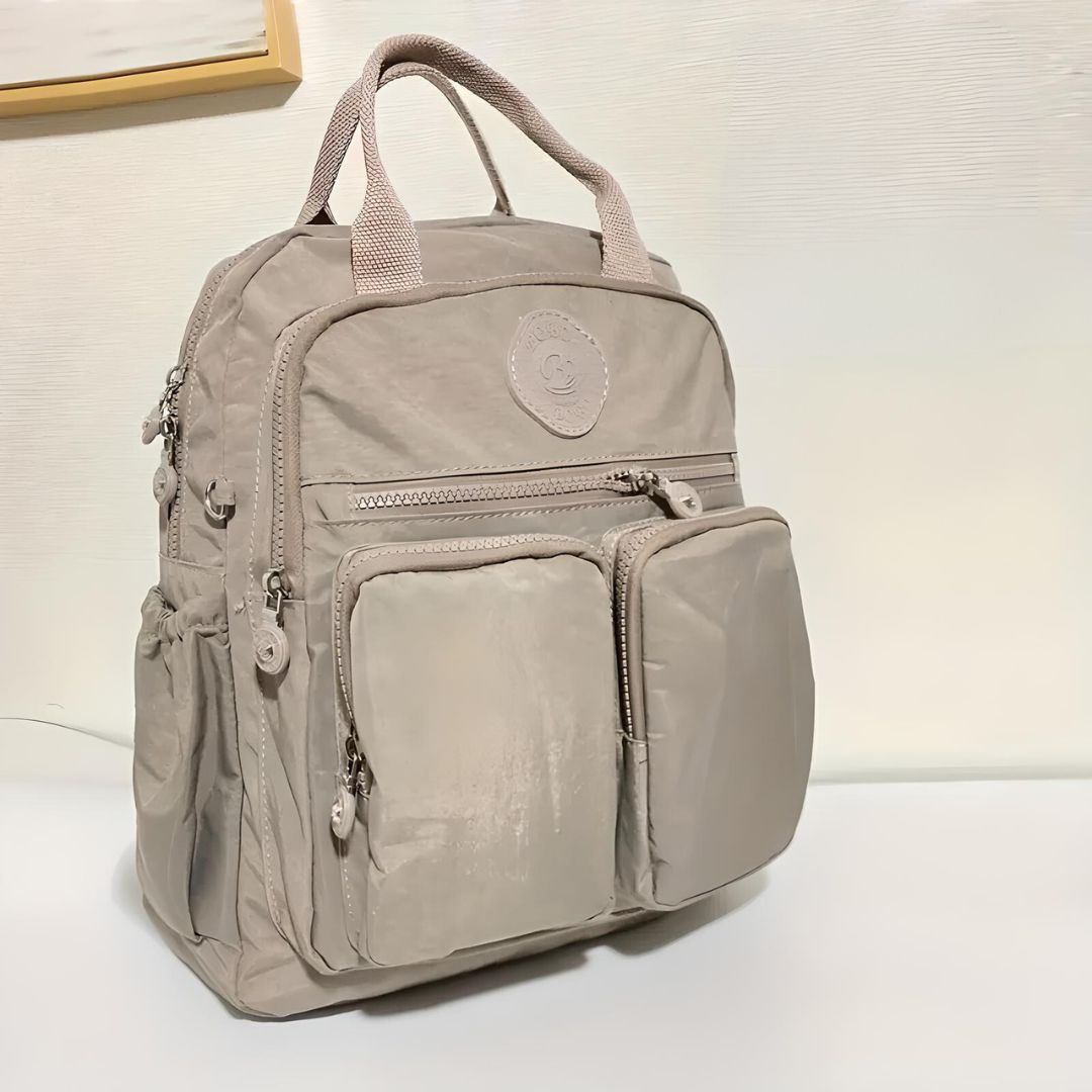 Beiger Rucksack mit mehreren Taschen, Reißverschlüssen, ideal für Reisen, Schule, Alltag.