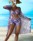 Frau in buntem Badeanzug mit geometrischem Muster und passendem Strandkimono am Strand. Sommermode, Strandbekleidung, stilvoller Look.