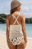 Frau am Strand in modischem Badeanzug mit Zebramuster und Strohhut. Sommermode, Strandbekleidung, Damenbademode, Urlaub, Strandoutfit.