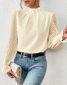 Elegante Damenbluse mit transparenten Ärmeln, kombiniert mit blauer Jeans und schwarzem Gürtel. Perfekt für modische Outfits und Casual-Looks.