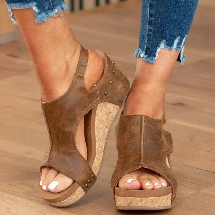 Damen Sandalen mit Keilabsatz aus Kork, braunem Leder, offener Zehenpartie und Nieten. Perfekt für Sommermode und lässige Outfits.