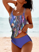 Frau im farbenfrohen Tankini am Strand, blauer Hintergrund, florales Design, Sommermode, Bademode, Strandbekleidung, Urlaub, Damenmode.