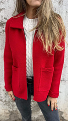 Rote Damenjacke aus Wolle, kombiniert mit weißem Strickpullover. Modische Herbstbekleidung, ideal für kühle Tage. Eleganter, zeitloser Stil.