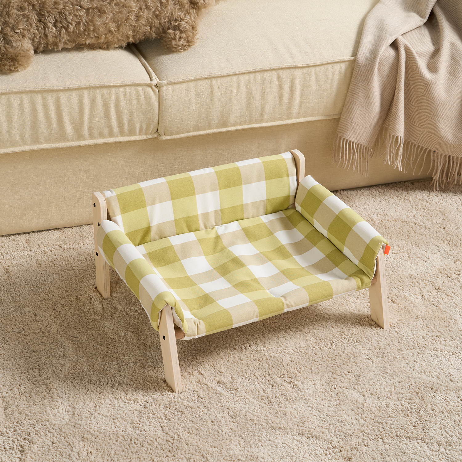 Grün-weiß karierter Haustier-Lounger aus Holz, ideal für kleine Hunde oder Katzen, auf Teppich.