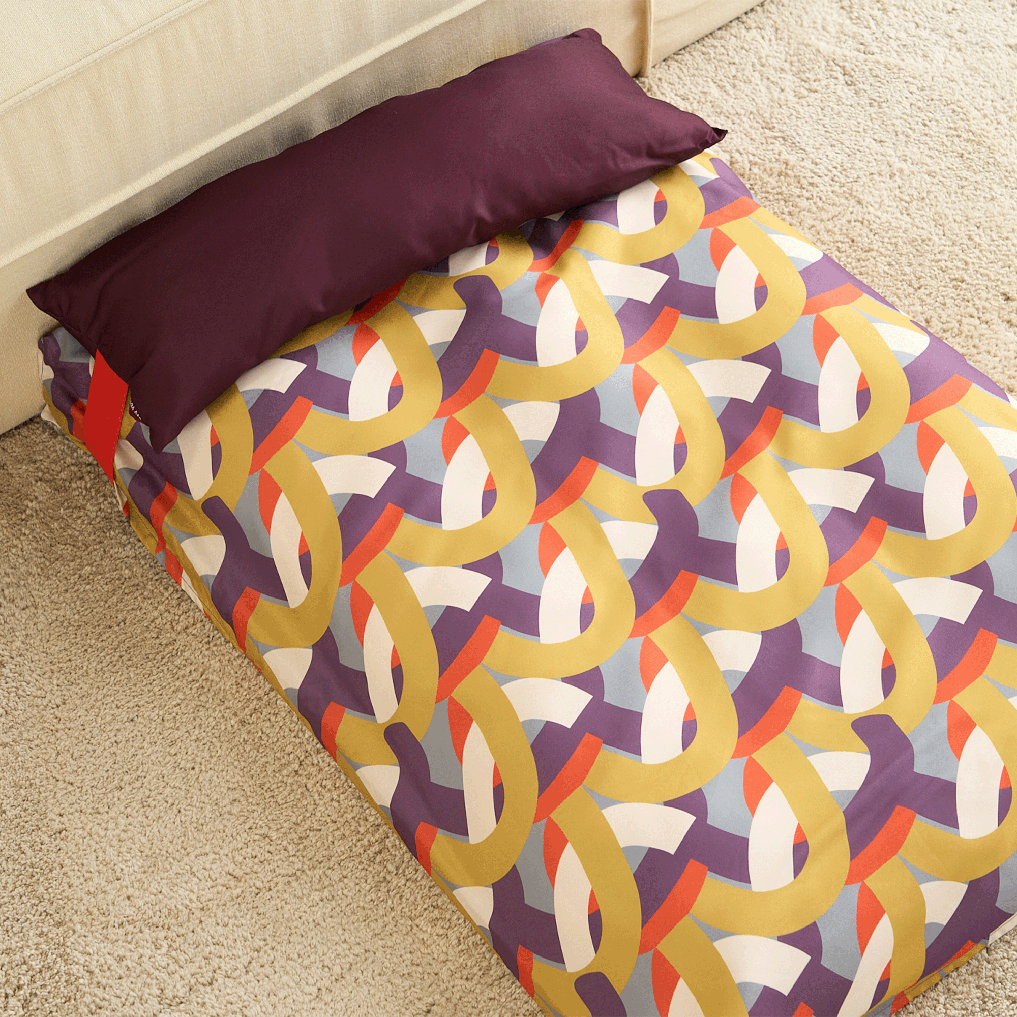 Buntes Hundebett mit geometrischem Muster, weiche Polsterung, ideal für Haustiere, modernes Design.
