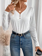 Damenmode: Weißes Langarmshirt mit Lochstickerei, V-Ausschnitt und Knopfleiste, kombiniert mit blauer Jeans. Eleganter Freizeitlook.