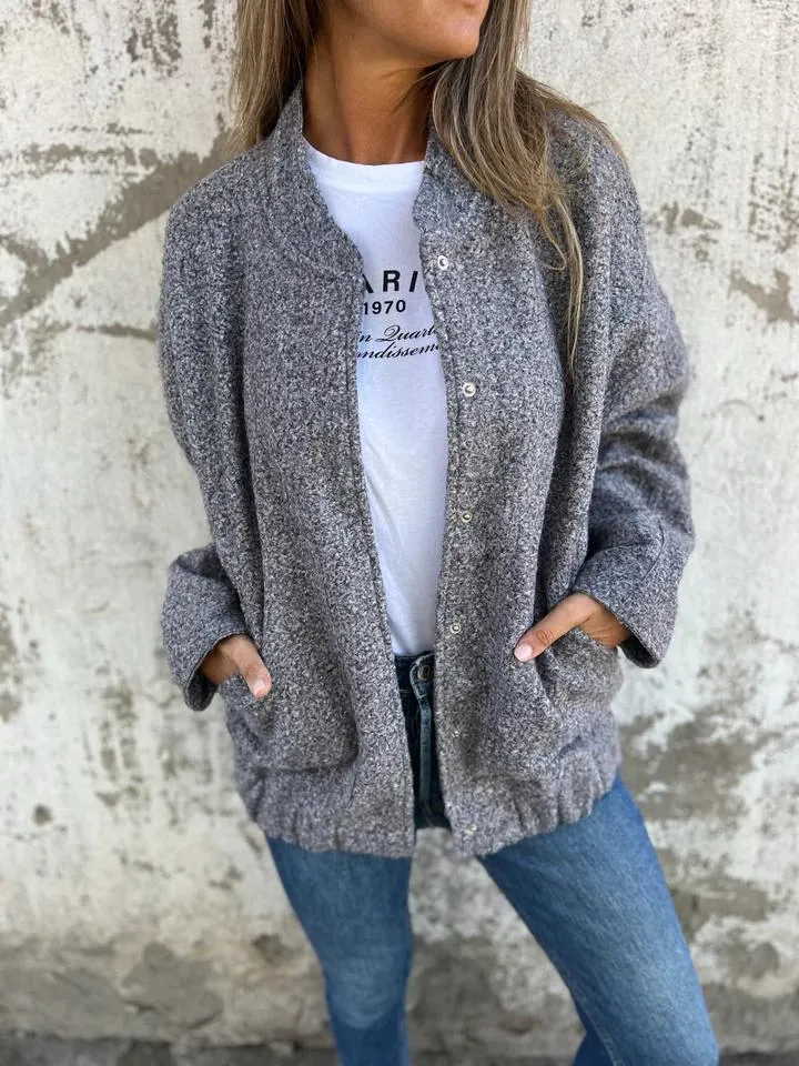 Graue Strickjacke Damenmode, lässig und stilvoll, kombiniert mit weißem T-Shirt und blauer Jeans. Perfekt für Herbst-Outfits und Streetstyle.