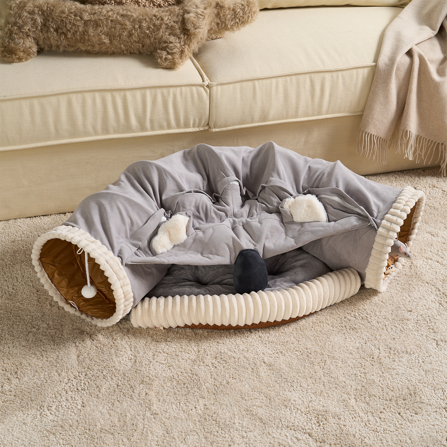 Graues 2-in-1-Katzenbett aus Plüsch, Koala-Design, gemütlich, waschbar, auf Teppich vor Sofa.