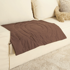 Braune Haustiermatte auf beigem Sofa, waschbar, rutschfest, ideal für Hunde und Katzen.