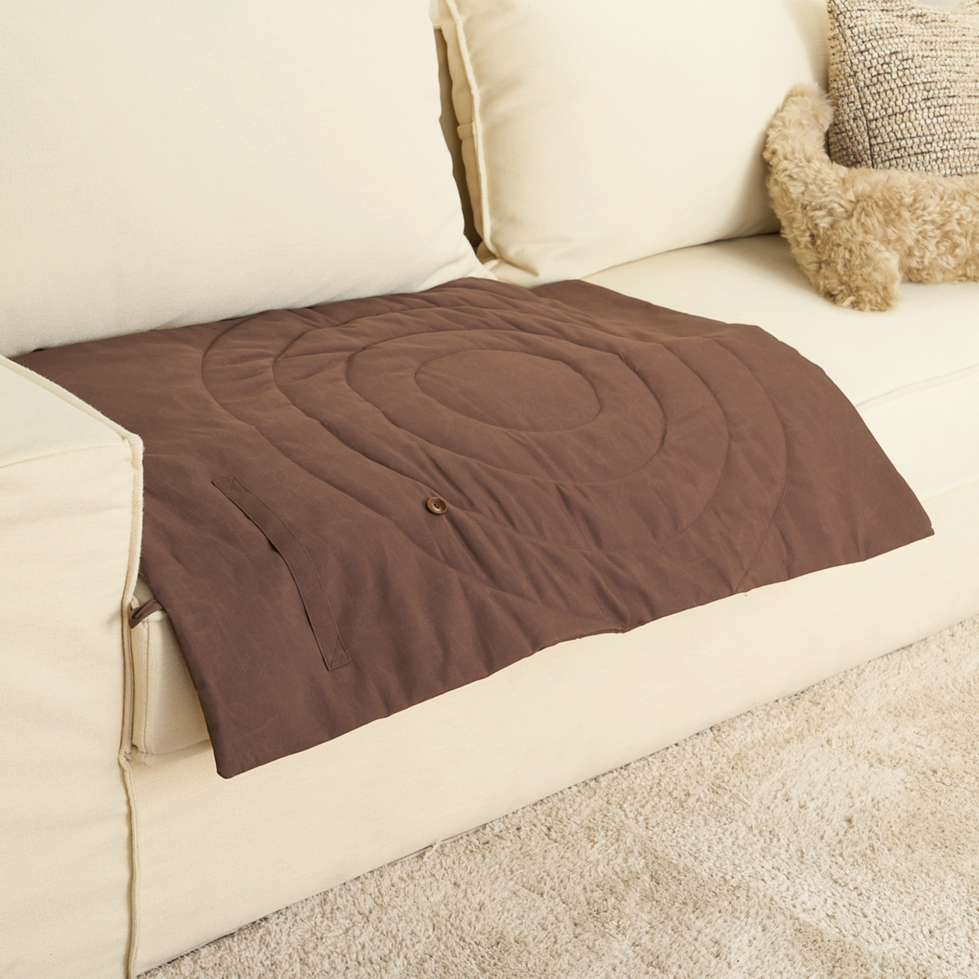 Braune Haustiermatte auf beigem Sofa, waschbar, rutschfest, ideal für Hunde und Katzen.
