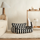Schwarz-weiß gestreiftes Hundebett auf Teppich, modernes Design, gemütlich, waschbar.
