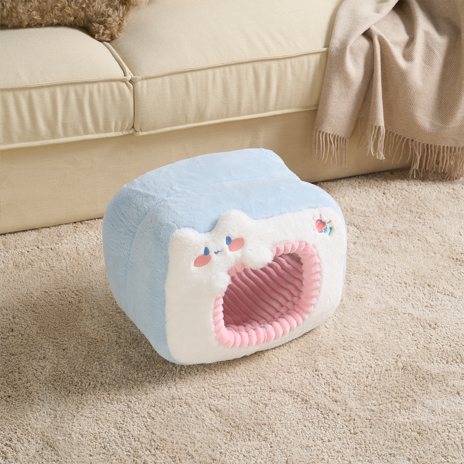 Katzenbett aus Plüsch, blau und rosa, gemütlich, für Katzen, auf Teppich vor Sofa.