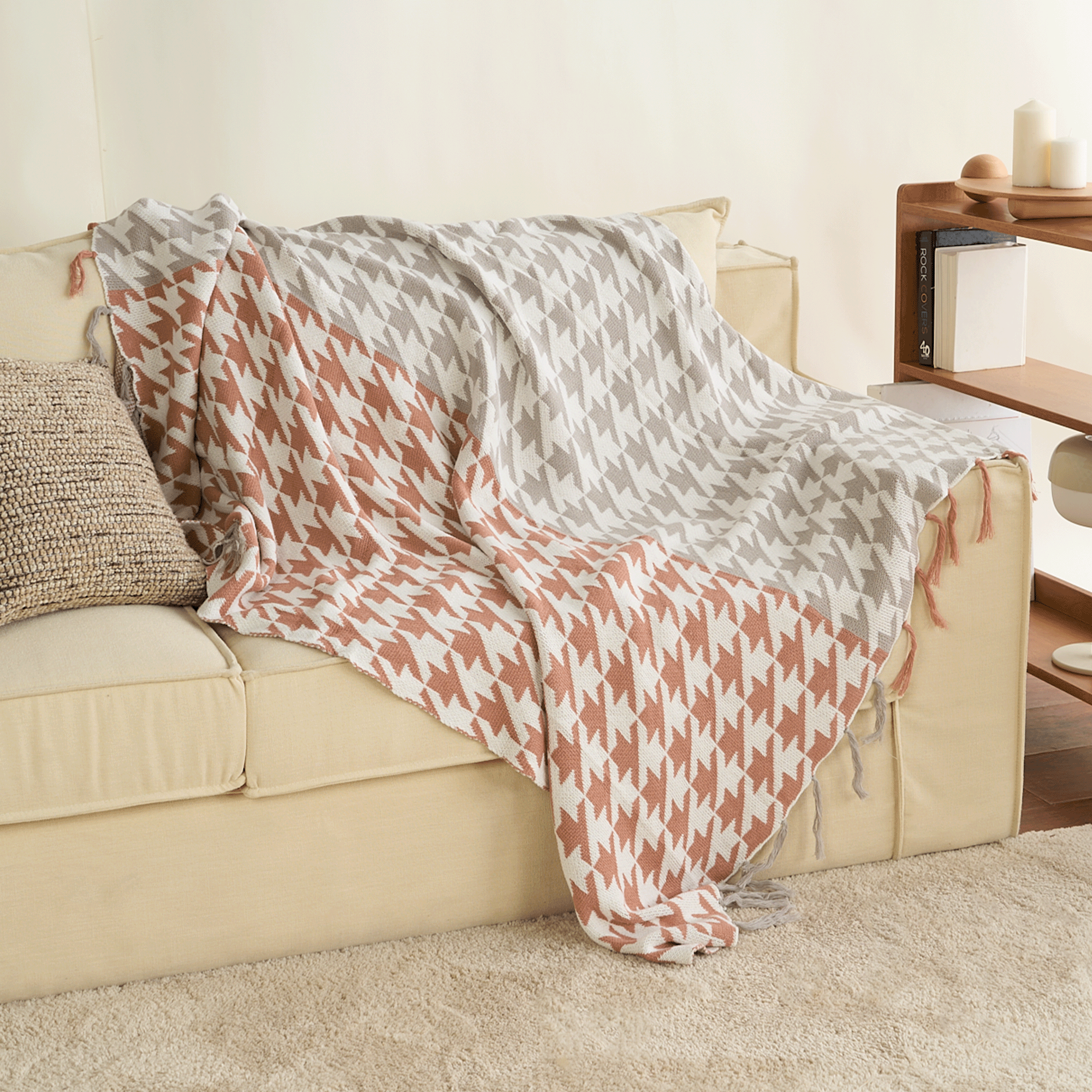 Beige Sofa mit Hahnentritt-Decke in Grau und Rostrot, Quasten, Wohnzimmer-Dekoration.