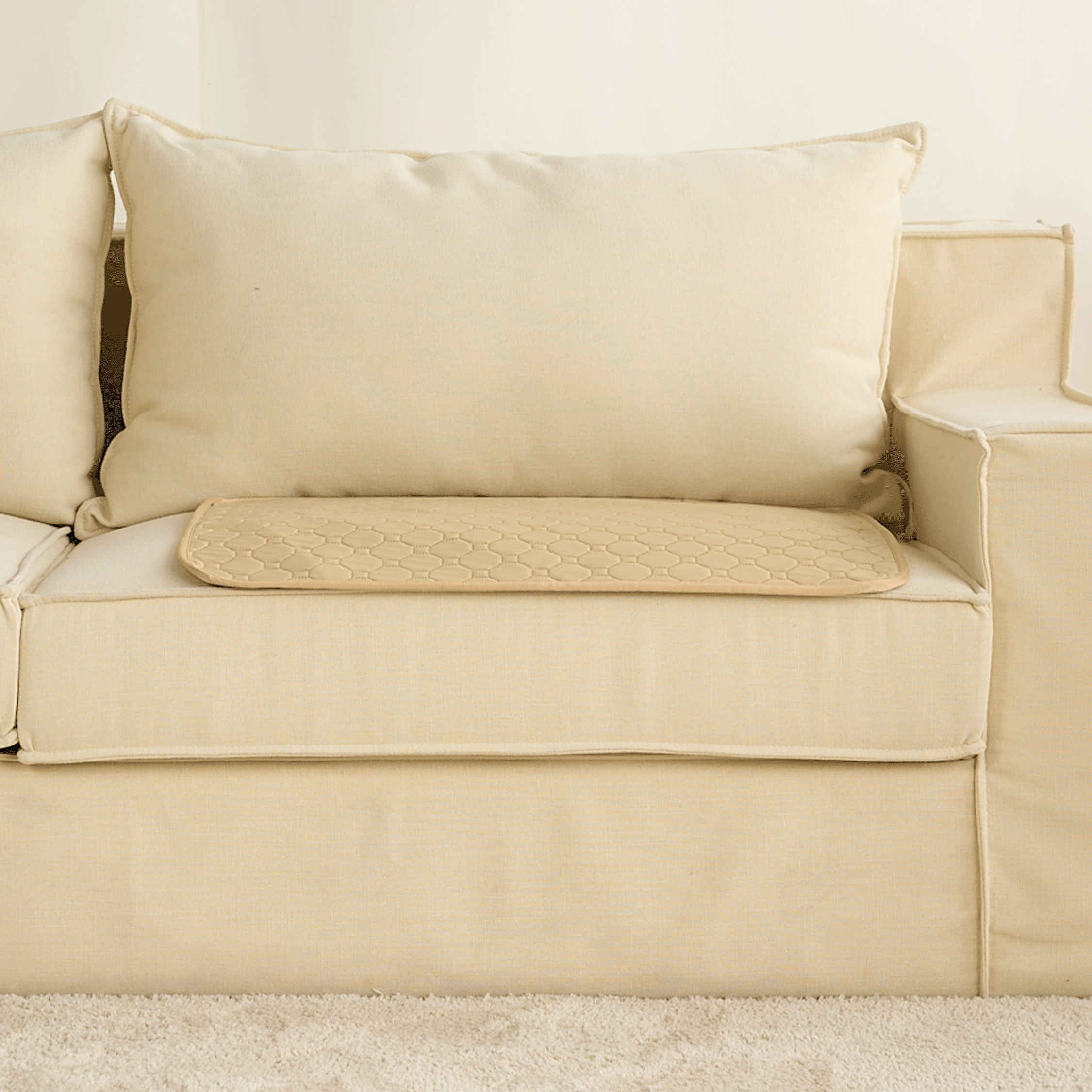Beige waschbare Hundematte auf cremefarbenem Sofa, rutschfest, ideal für Haustiere.